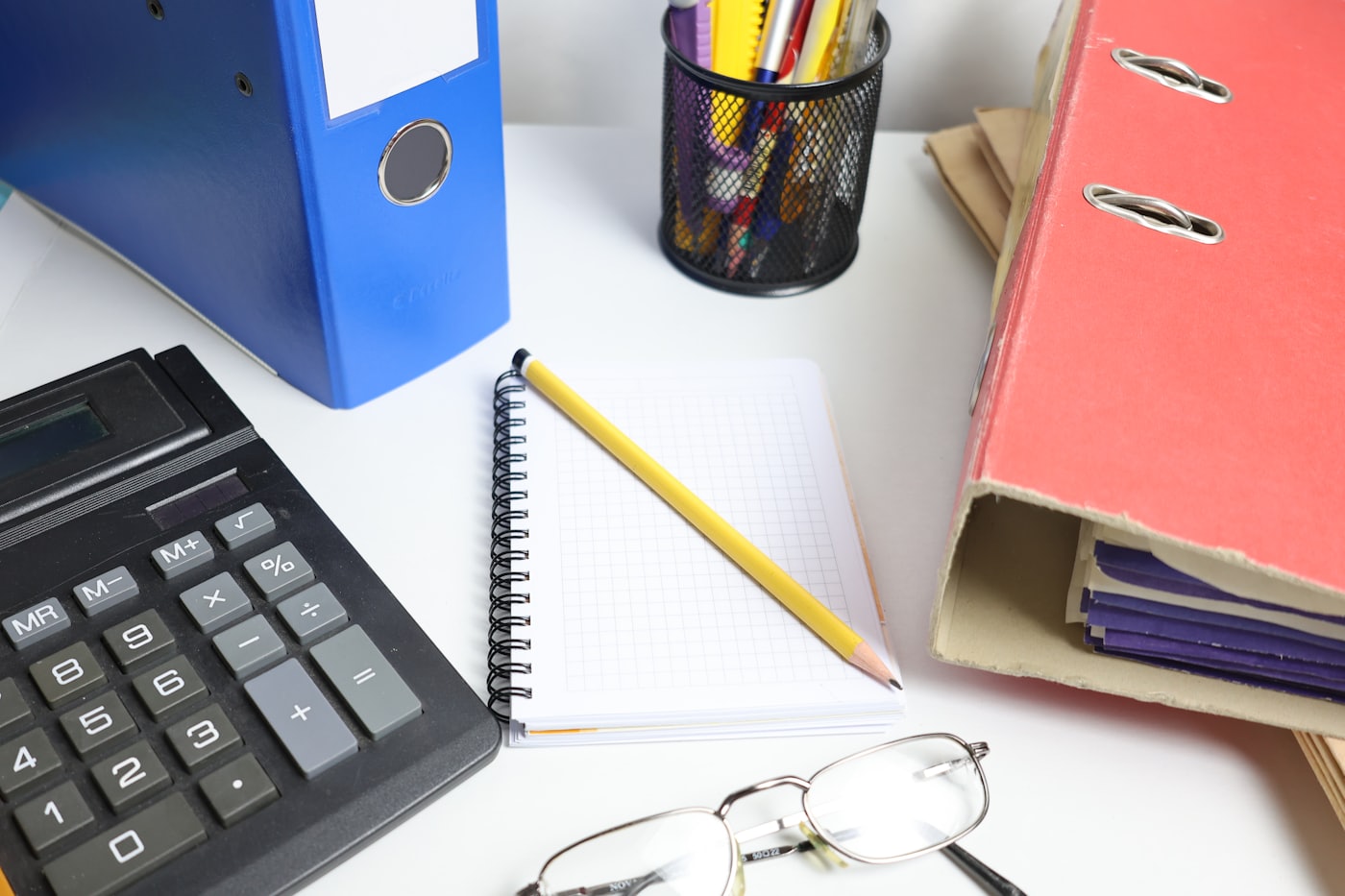 Escritorio de trabajo con calculadora, archivadores y documentación contable
